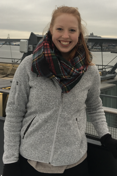 凯特 is smiling outside wearing a plaid scarf and gray jacket